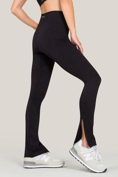 Alala women's seamless flare pant with slit in black Sleek Tight Bottoms For Yoga, Sleek High Stretch Bottoms For Pilates, Sleek Fitted Workout Bottoms, Sleek Yoga Pants, Chic Black Leggings With Minimal Stretch, Sleek High-stretch Yoga Bottoms, Fitted Activewear For Barre, Modern Fitted High-cut Leg Bottoms, Sleek High Stretch Yoga Bottoms