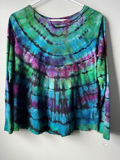 a tie dyed shirt hanging on a wall