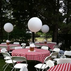 tables with red and white checkered tablecloths are set up for an outdoor party