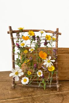 a basket filled with flowers sitting on top of a wooden table