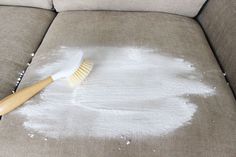 a brush is laying on the couch that has been smothered with white stuff