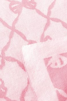 a close up view of a pink and white blanket with an intricate design on it