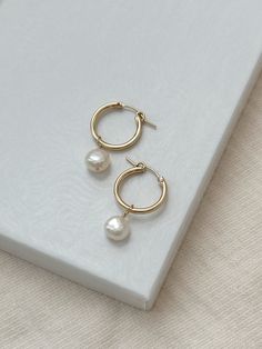 A classic pair of Pearl hoops has the power to elevate any outfit! The minimalist earrings design looks gorgeous paired with both casual and dressy outfits. The lightweight hoop latches to stay in place all day!  The Pearl charms can even be removed for a more casual look! * 18mm 14K Gold Filled or 925 Sterling Silver Hoops * 14/20 gf or 925 stamp for authenticity * Made with all hypoallergenic materials 🤍  ✨  Shop all Pearl earrings here!: https://etsy.me/3Xiy4c5 GET TO KNOW MAGBEE JEWELRY! ✨ Everyday Yellow Gold Pearl Earrings, Small Hoop Pearl Earrings For Everyday, Minimalist Small Hoop Huggie Earrings With Pearl Drop, Everyday Small Hoop Pearl Earrings, Minimalist Pearl Drop Small Hoop Huggie Earrings, Classic Everyday Pearl Earrings Tarnish Resistant, Minimalist Small Hoop Pearl Earrings For Anniversary, Minimalist Yellow Gold Pearl Earrings For Everyday, Minimalist Everyday Pearl Huggie Earrings