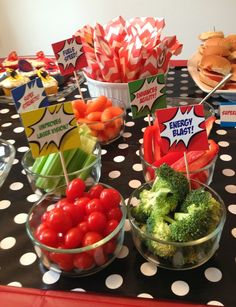 a table topped with bowls filled with veggies and sandwiches on top of it