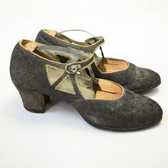 "Vintage 1920s brocade heels with cut-outs and a sweet mother of pearl button closure. Details Era: late 1920s Label: none Fabric: brocade outer, leather inner Color*: dark grey with metallic threads Closure: button Measurements* Outer sole length: about 10\" Inner sole length: 9.25\" Ball width: 3\" Heel height: 2\" *It is best to compare these measurements to those of a well-fitting pair of heels in your own closet. Condition Fair, with fading and darkening to the metallic thread throughout. The piping is also yellowed and there are some faint marks and nicks throughout (see images). Still in wearable condition with plenty of charm. *Color displays differently on various computer monitors. FAQs: Q: Do you offer discounts or accept offers? A: While we do not accept offers, you can follow 20s Shoes, Shoes Teen, Metallic Thread, Mother Of Pearl Buttons, Patent Leather, Clothing Items, Me Too Shoes, Heel Height, Pumps