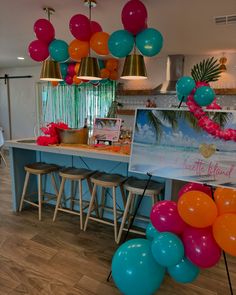 balloons are hanging from the ceiling in front of a counter