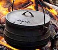 a pot sitting on top of a camp fire