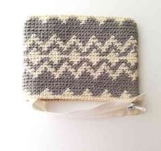 a crocheted purse with a white ribbon