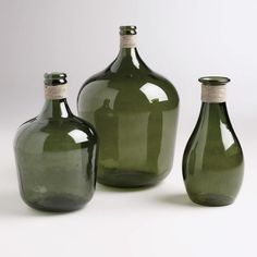 three green glass vases sitting next to each other