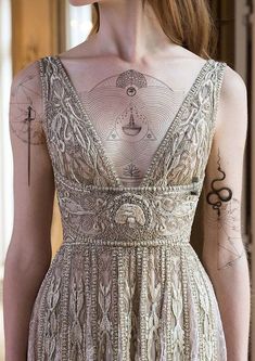 the back of a woman's dress with tattoos on it