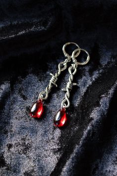 These barbed wire earrings with red glass drop beads have a Goth vibe. A subtle one. They would be perfect for Halloween or whenever you feel a little blood-thirsty - happens to the best of us, doesn't? ;) DIMENSIONS: The length will vary depending on the ear-wires of your choice: With base metal hooks: 2 5/8" (6.7 cm) With sterling silver hooks: 2 9/16" (6.5 cm) With sterling silver or base metal lever backs: 2 7/16" (6.2 cm) With base metal or sterling silver studs: 2 1/16" (5.2 cm) With clip- Cute Goth Jewelry, Diy Goth Earrings, Edgy Red Earrings As Gift, Edgy Red Earrings For Gift, Edgy Red Earrings For Gifts, Handmade Vampire Style Jewelry For Cosplay, Vampire Style Dangle Jewelry For Gift, Vampire Style Dangle Jewelry Gift, Blood Drop Earrings