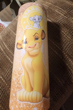 the lion king bottle has been painted on it's side and is sitting on a couch