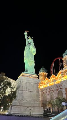 the statue of liberty is lit up at night