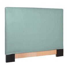 an upholstered headboard with wooden legs and blue fabric on the top, in front of a white background