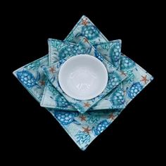 three blue and white plates sitting on top of each other in front of a black background