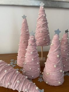 three pink christmas trees on a wooden table