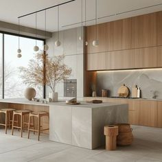 a modern kitchen with marble counter tops and wooden cabinetry, along with stools