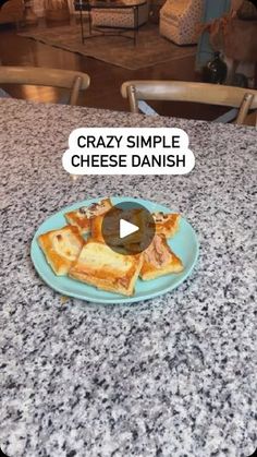 a blue plate topped with toasted cheese on top of a counter next to chairs