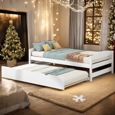 a white bed sitting on top of a wooden floor next to a christmas tree in a bedroom