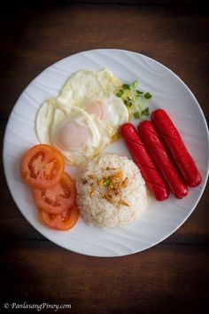 a white plate topped with rice, tomatoes and eggs