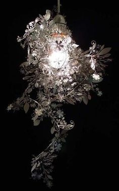 a chandelier hanging from the ceiling with flowers and leaves on it's sides