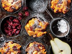 muffins with apples and cranberries in black cups on a baking tray