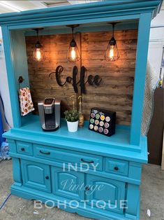 a blue hutch with lights on top and coffee maker in the corner, next to it