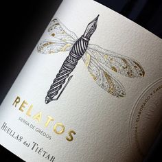 a bottle of red wine with a dragonfly on it's label and the word relaxos written in spanish