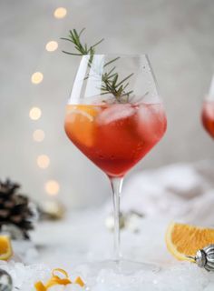 two glasses filled with red wine and garnished with rosemary