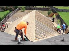 three men are working on the roof of a building