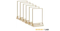 four gold metal racks with five stars on each side and one is holding a white sign