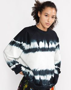 a woman wearing a black and white tie dye sweater