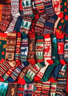 many different colored socks with moose and snowflakes on them, all lined up next to each other