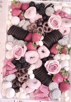 a box filled with lots of different types of donuts and strawberries on top of each other