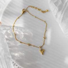 ✦ Add some romance and sparkle to your summer look with our Dainty Gold Heart Anklet Chain. This beautiful ankle bracelet features a delicate gold chain adorned with a heart-shaped pendant and sparkling rhinestones, giving you a simple yet elegant look. Perfect for any occasion, this anklet is both glamorous and versatile, making it a great addition to your summer jewelry collection. ----------- DETAILS ------------ Color: Gold - Chain Length: 23-24cm - Materials:316L Stainless Steel, Cubic Zirc Heart-shaped Metal Anklets For Gift, Heart-shaped Metal Anklets As Gift, Trendy Heart-shaped Anklets For Valentine's Day, Elegant Heart Charm Anklets For Valentine's Day, Elegant Heart-shaped Anklets For Valentine's Day, Gold Heart Anklets, Trendy Gold Heart-shaped Anklets, Gold Heart Bracelet With Delicate Chain, Elegant Gold Anklets With Heart Charm