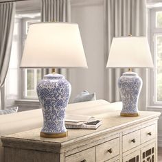 two blue and white vases sitting on top of a table next to a lamp