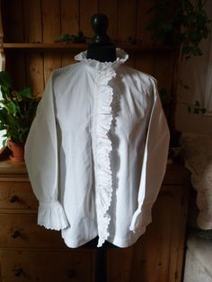 "Gorgeous example of a fine 1900's French long sleeve blouse in crisp white French cotton. Monogram A.C.  4 original mother of pearl buttons Intricate lace and white work, broderie anglaise with scalloped edging. Beautiful frill around the collar, front placket & cuffs. One faint rust mark in front (see photo) There are two listings with almost identical blouses except this one has a slight rust mark priced accordingly. Measurements  Bust 40\" Sleeve length 20\" Cuff 4.5\" across  Shoulder 5.5\" Length at back 25\" Collar 16\" Frill 1.5\" Underarm 9\" Upper arm width 8.5\" This garment must be hand washed with gentle soap with no bleaching agents. Sourced in Languedoc by myself. Please note; These items are not new and have lived long and eventful lives.  Antique fabrics mostly have flaws White Cotton Blouse, Antique Fabrics, Linens And Lace, French Linen, Mother Of Pearl Buttons, White Shirts, Cotton Blouses, Cut Work, White Cotton