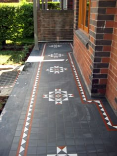 the walkway is painted with white and orange designs on black tiles, along with red brick walls