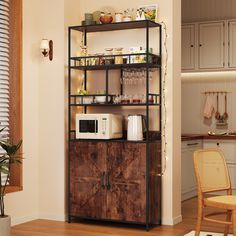 a kitchen area with a microwave, cabinet and chair in it's centerpiece