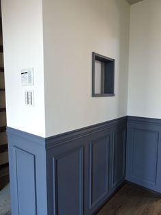 an empty room with blue paneling and white walls