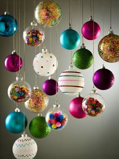 a bunch of ornaments hanging from the ceiling in different colors and sizes, all decorated with confetti or sprinkles