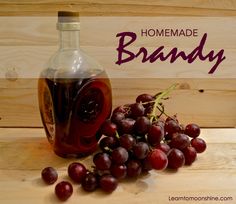 a bottle of homemade brandy next to grapes