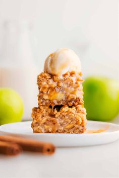 two pieces of apple crisp bars on a plate with ice cream and cinnamon sticks in the background