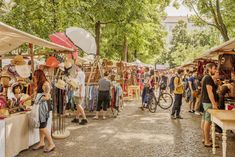 many people are shopping at an outdoor market