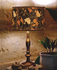 a lamp sitting on top of a table next to a potted plant and other items