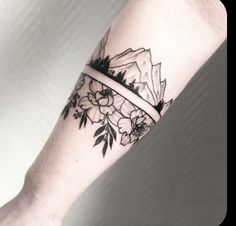 a woman's arm with a flower tattoo on it and a band around the wrist