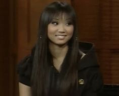 a woman with long black hair sitting down