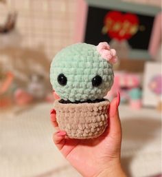 a small crocheted cupcake with a pink bow on it's head