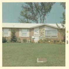 an old photo of a house in the grass