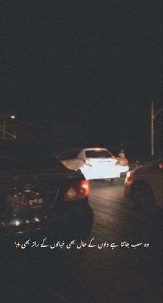 two cars parked in the street at night with an advertisement written in english and arabic